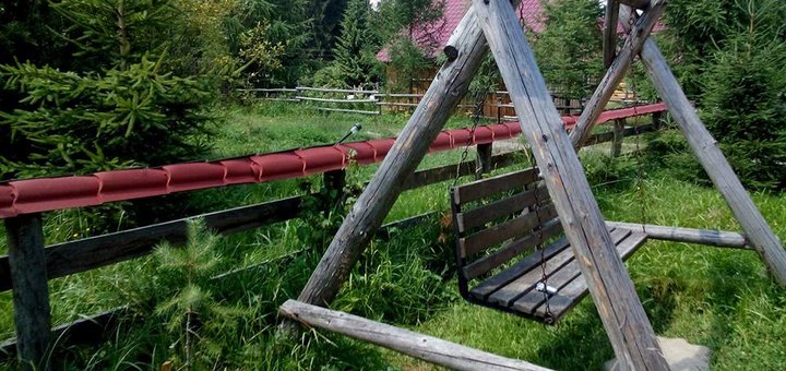 Деревянная качеля во дворе усадьбы «Урочище Багончик» в Ворохте. Бронируйте номера в мини-отеле по акции.